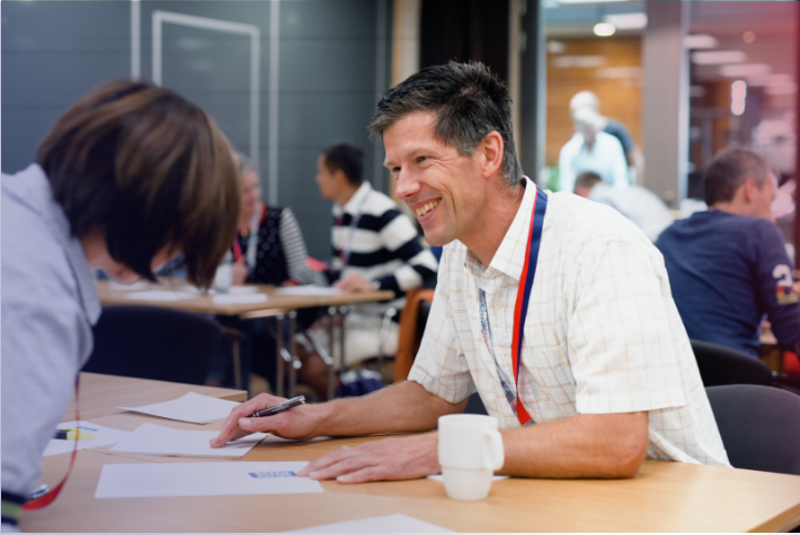 Two people sitting at a table looking at a paper 