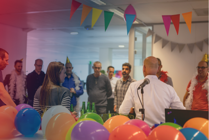 a group of employees in a room with a party atmosphere and balloons a group of employees in a room with a party atmosphere and balloons