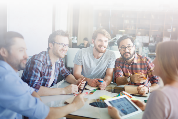 a group of people sitting together at a round table and talking