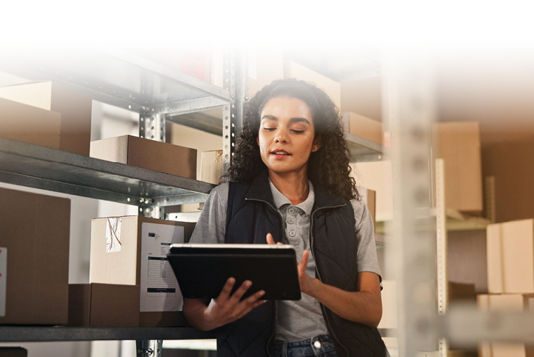 Warehouse Management for Small Business with worker using tablet to manage inventory on shelves