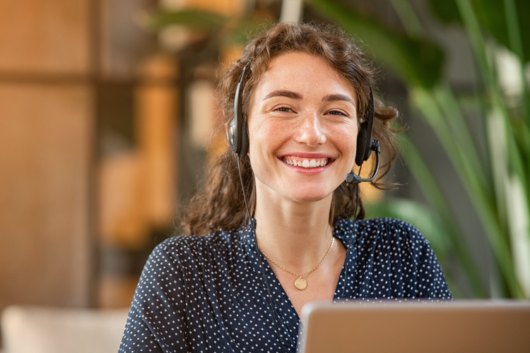 Smiling customer support representative with headset assisting clients using Astro Go WMS