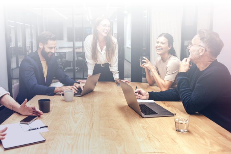 A group of Consafe Logistics employees who laugh in a meeting room