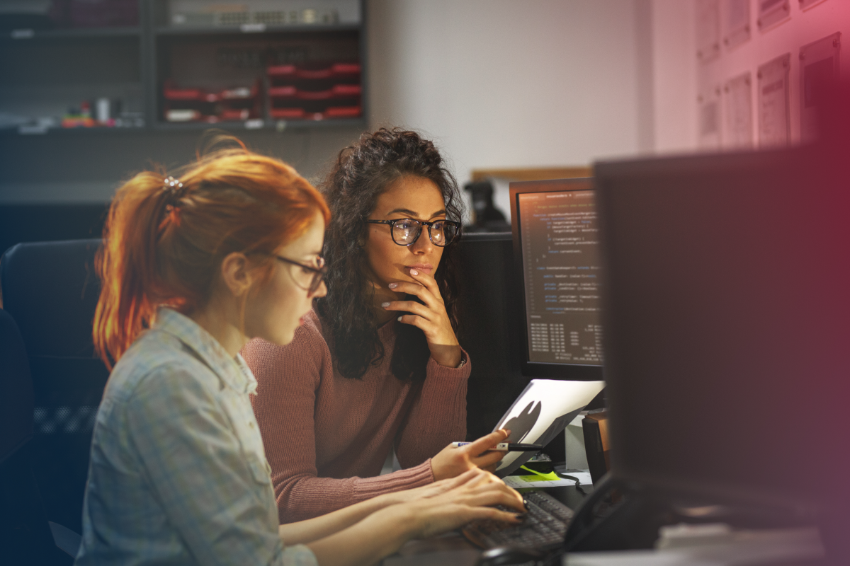 Two female developers sitting in front of a computer and working together