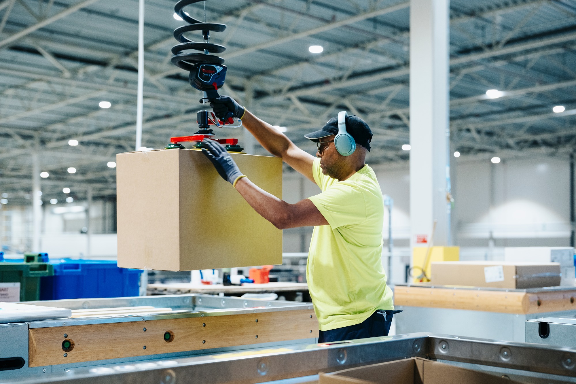 Warehouse worker at Dahl using a lifting device to move a large box, supported by efficient warehouse operations powered by Astro WMS®.