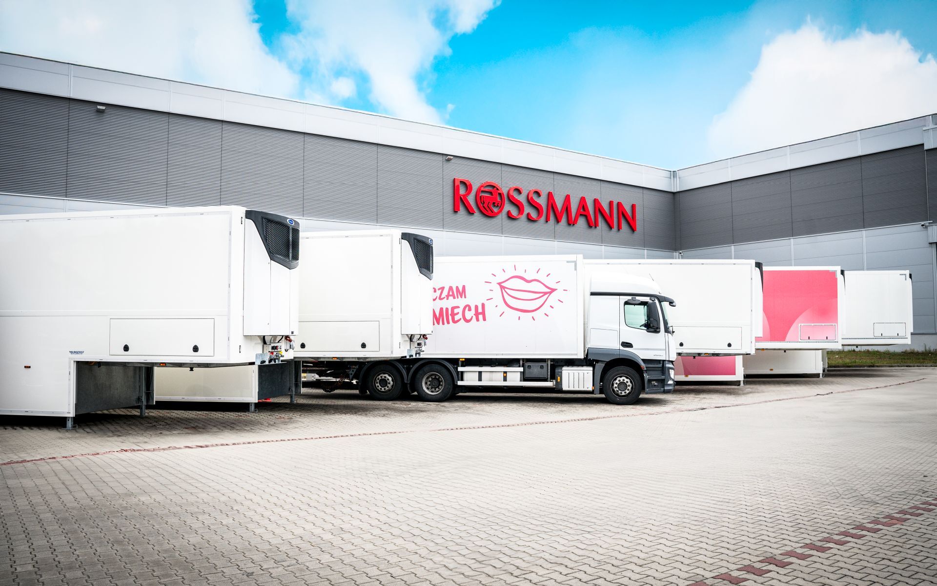 Rossmann warehouse exterior with company logo on the building and branded delivery truck parked outside