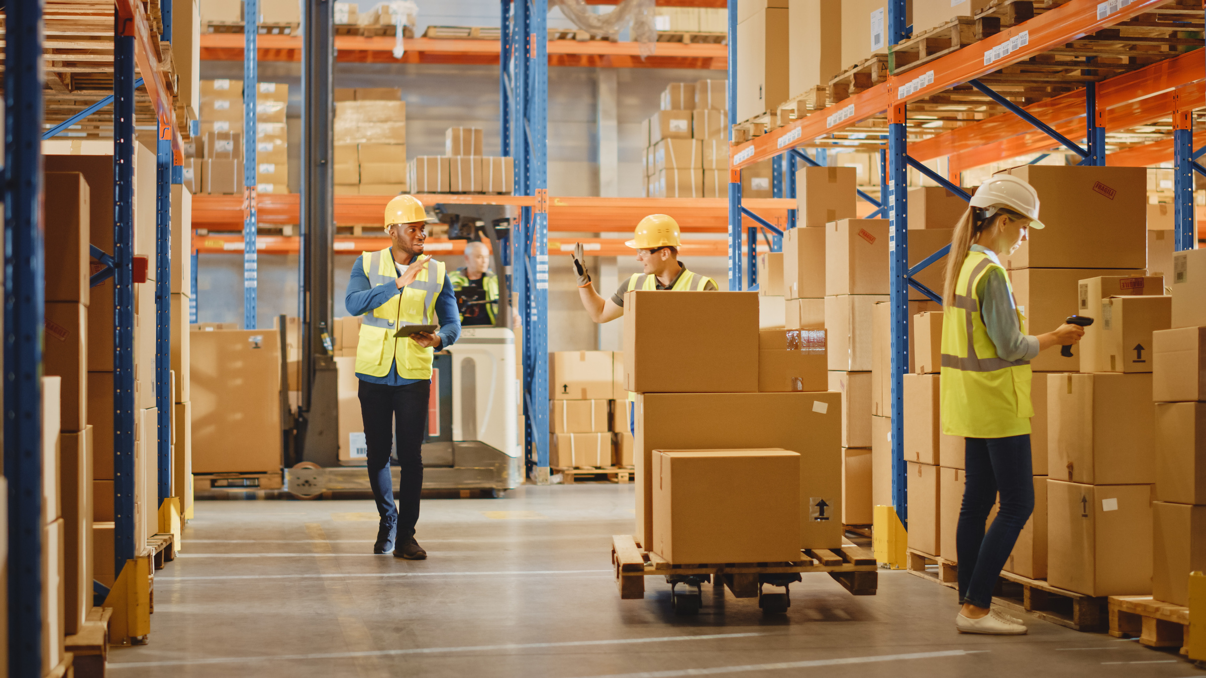 3PL warehouse with workers moving boxes and pallets – linked to Consafe Logistics’ Solid WMS acquisition press release