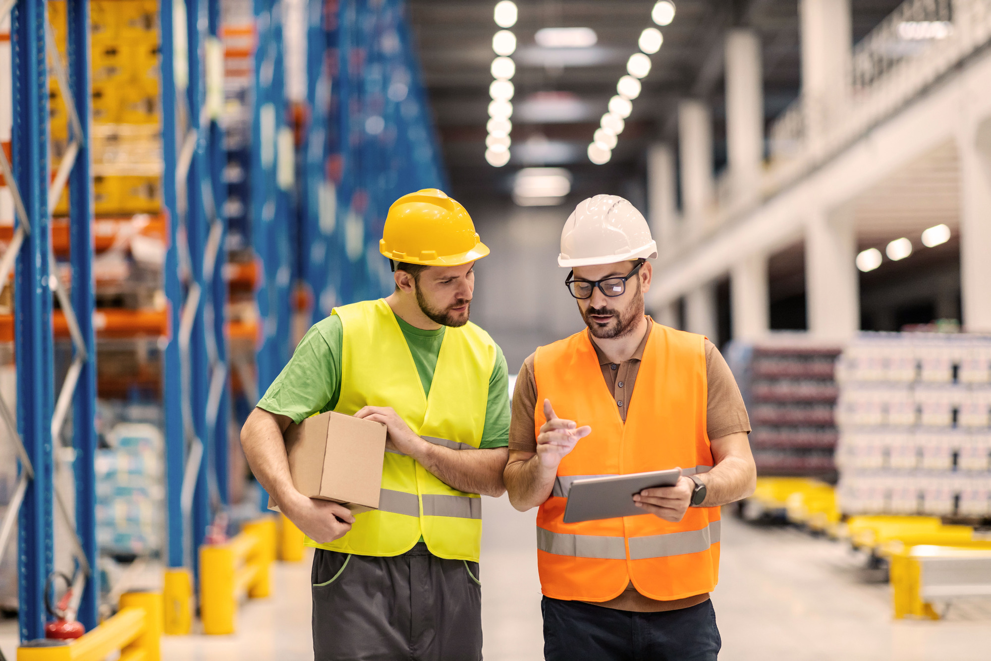 Warehouse staff reviewing data on a tablet in a modern warehouse, illustrating the Lexit Group and Consafe Logistics partnership