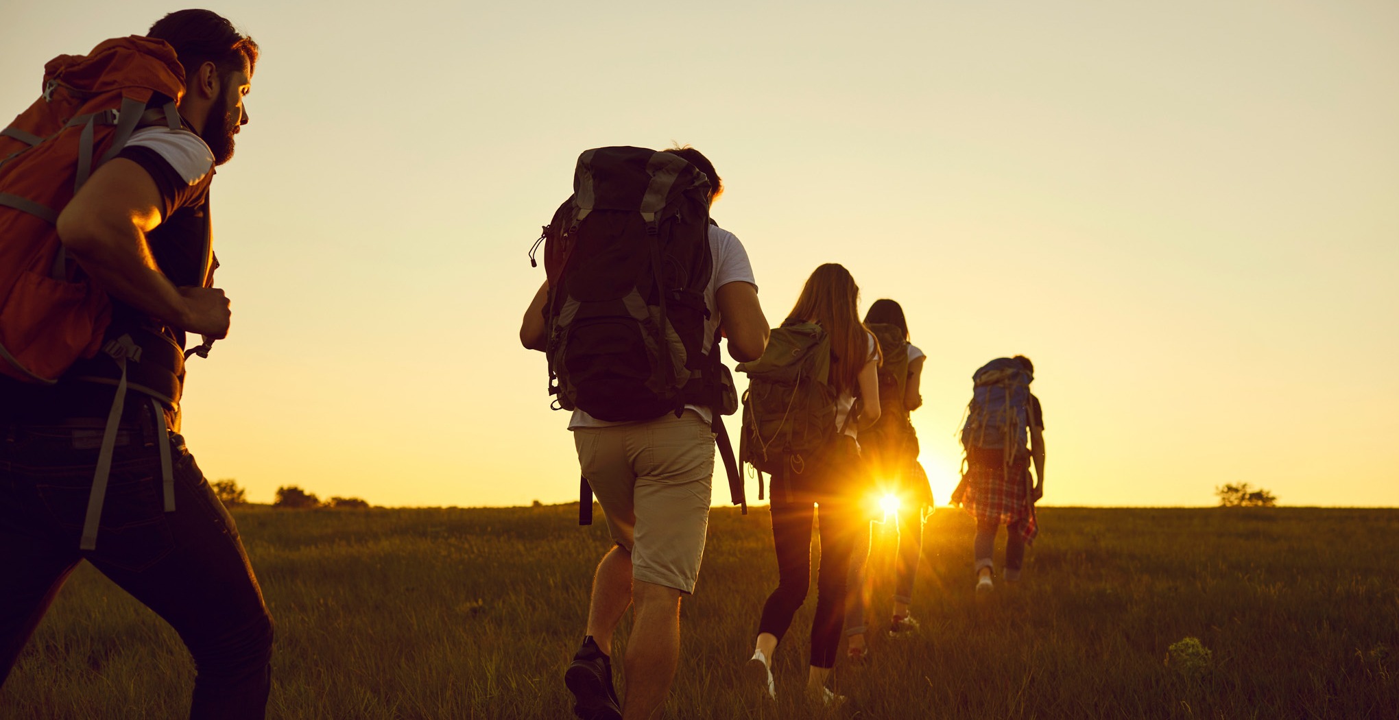 Group of young professionals confidently striding with backpacks, poised for success