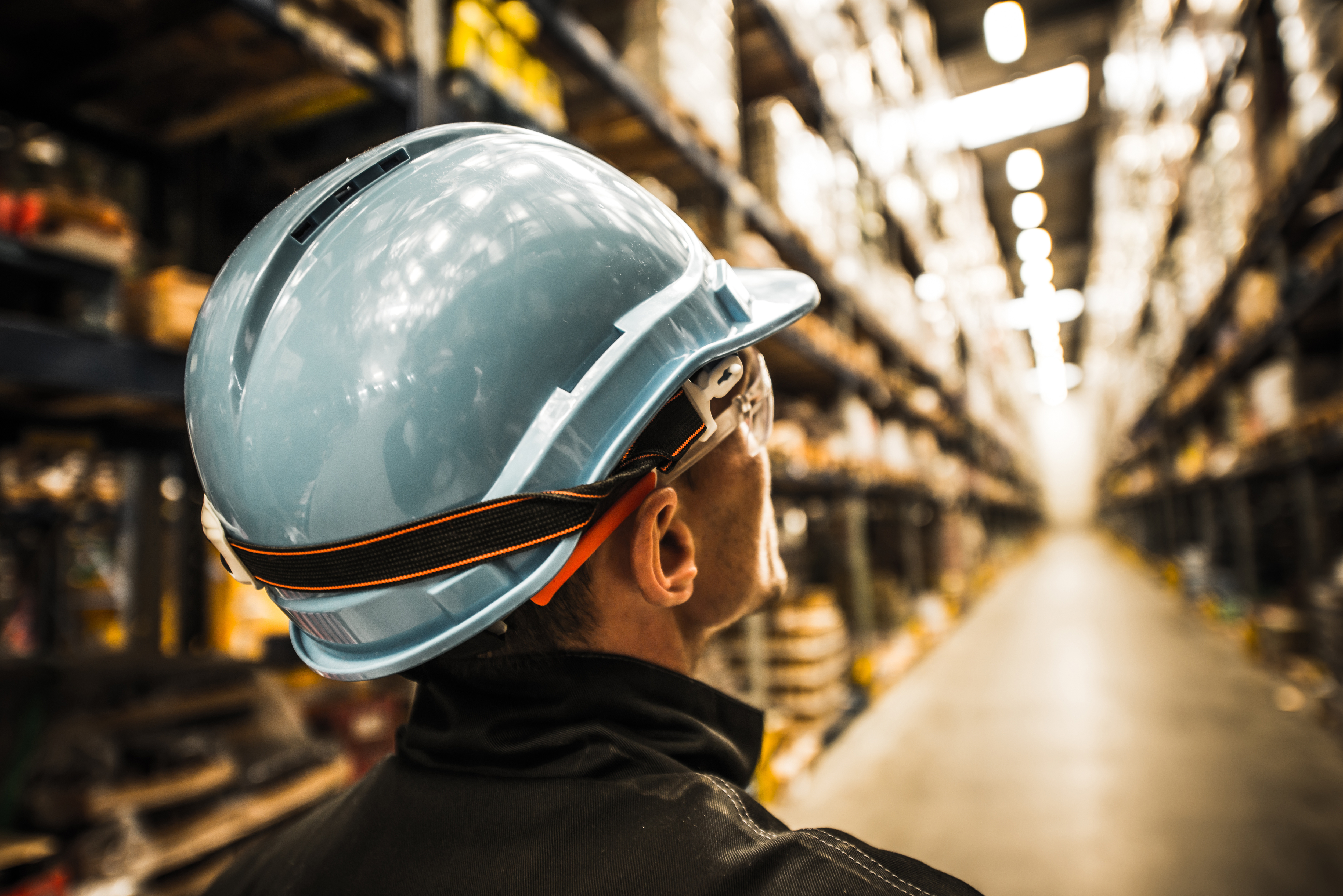 Warehouse worker in safety helmet looking at shelves, symbolizing that not all SaaS WMS solutions are created equal.