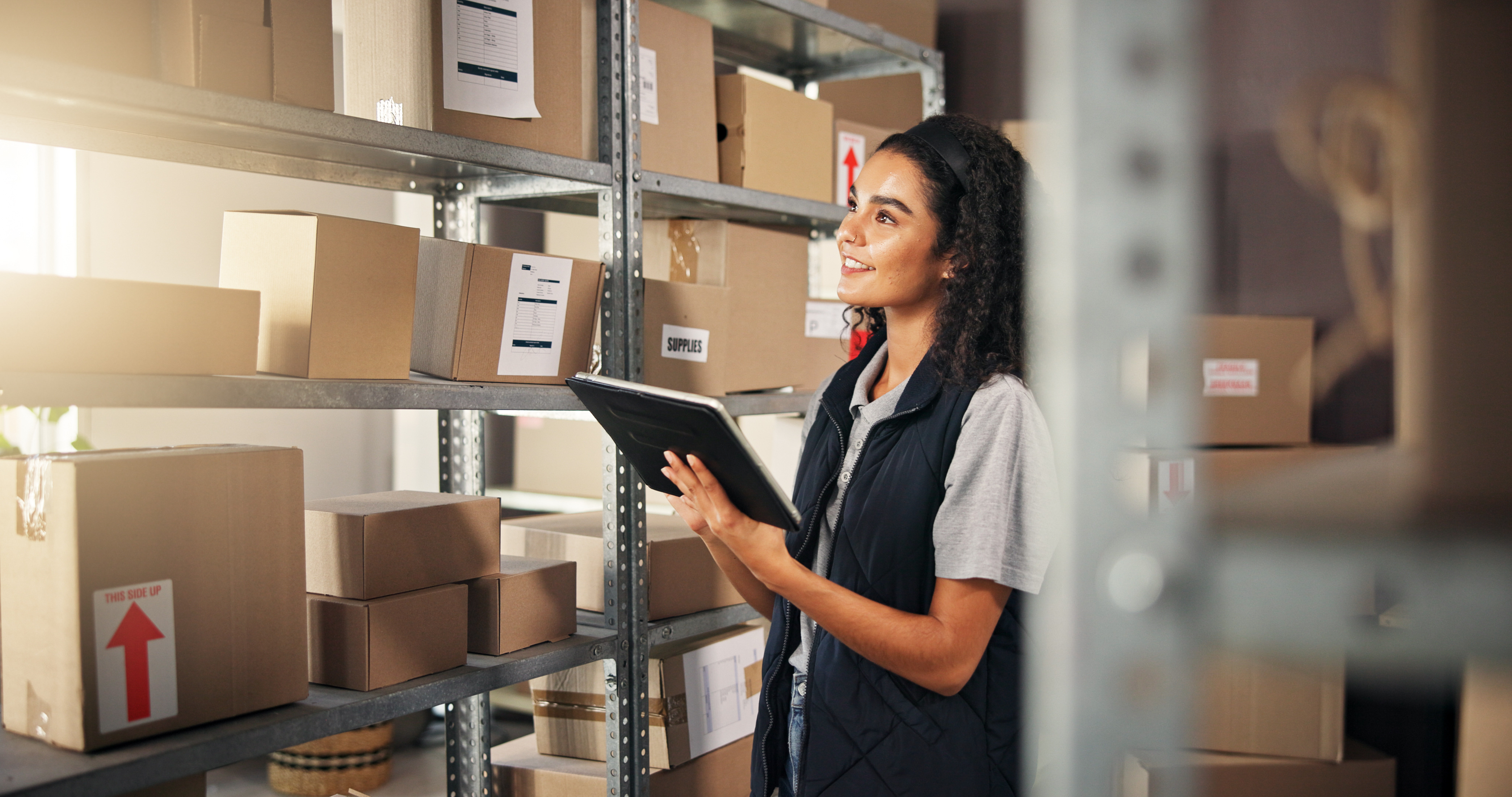 Warehouse management for small business with worker using tablet to manage inventory on shelves