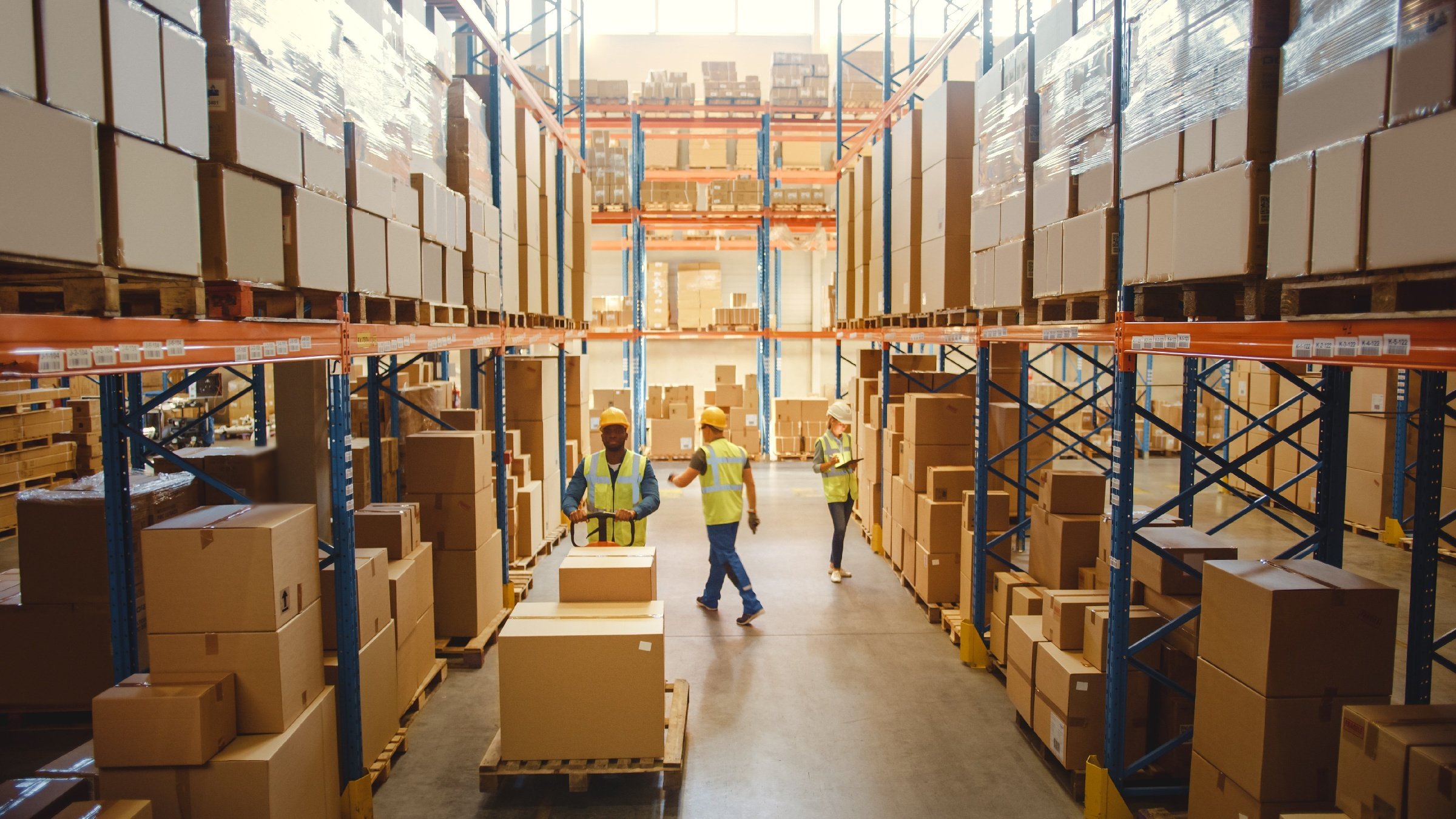 Warehouse worker doing warehouse optimization tasks in reflective vests, riding a forklift, packing orders.