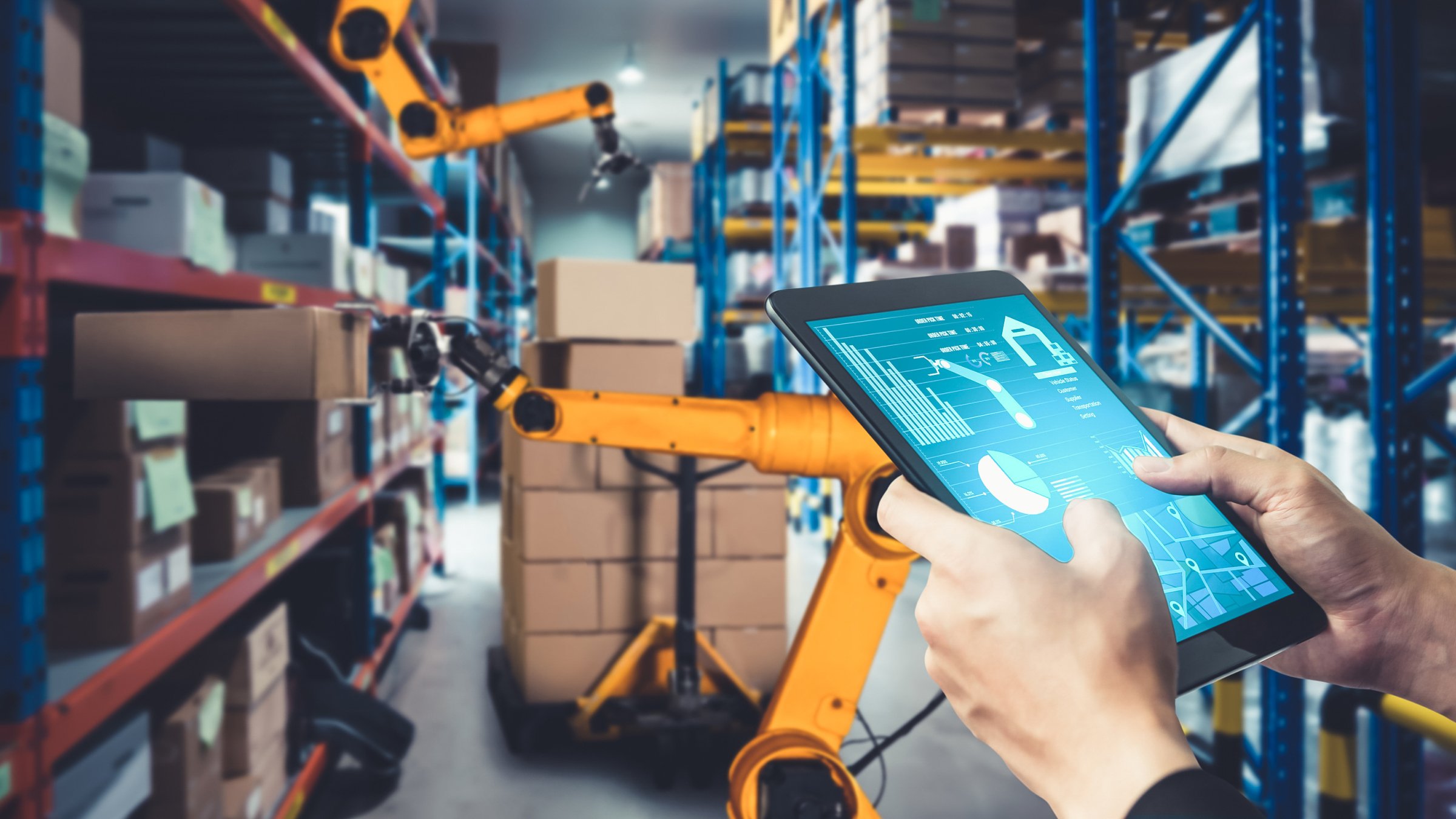 Hand holding a tablet and a smart robot arm systems for warehouse automation