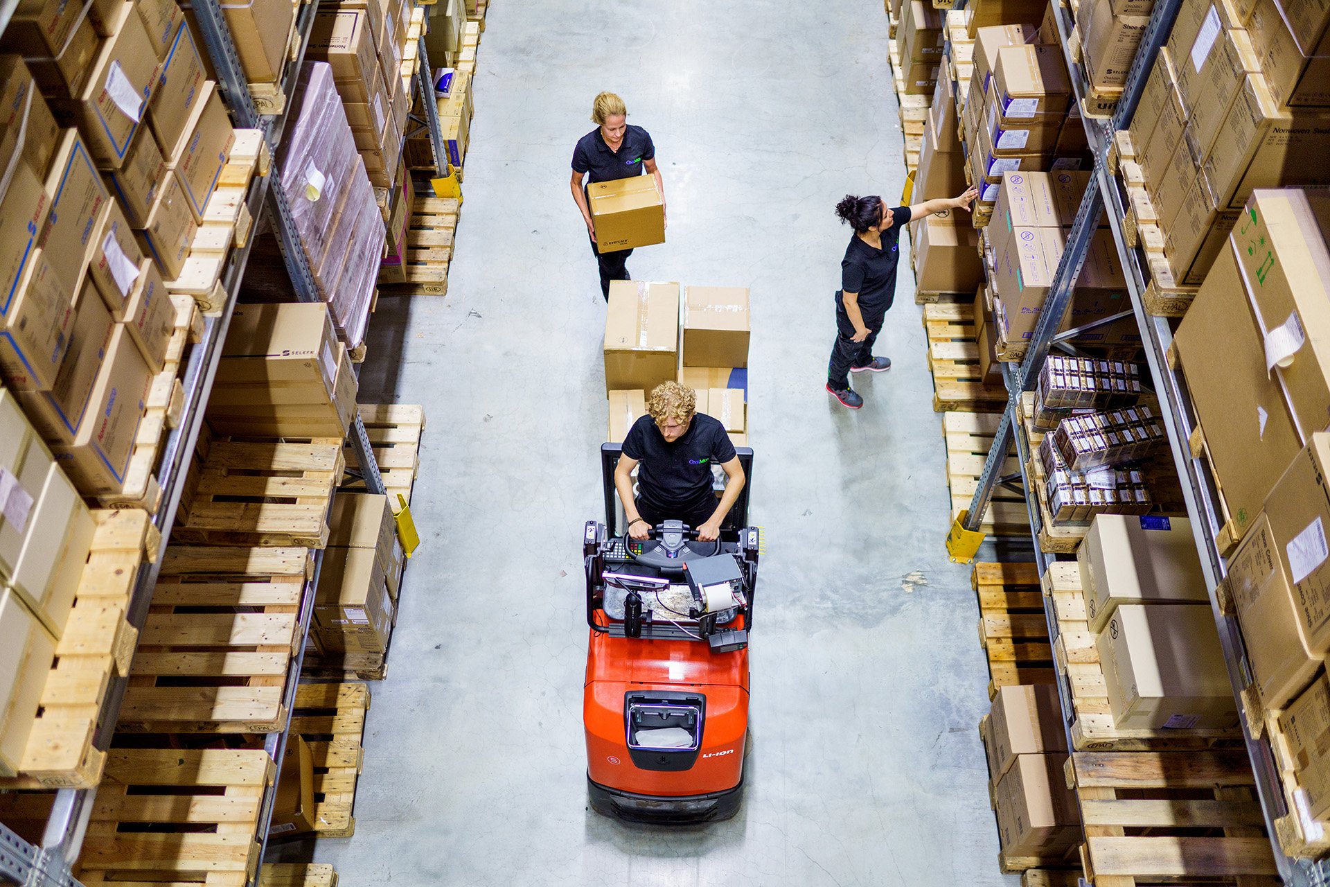Aerial view of OneMed warehouse with employee handling a truck and parcels