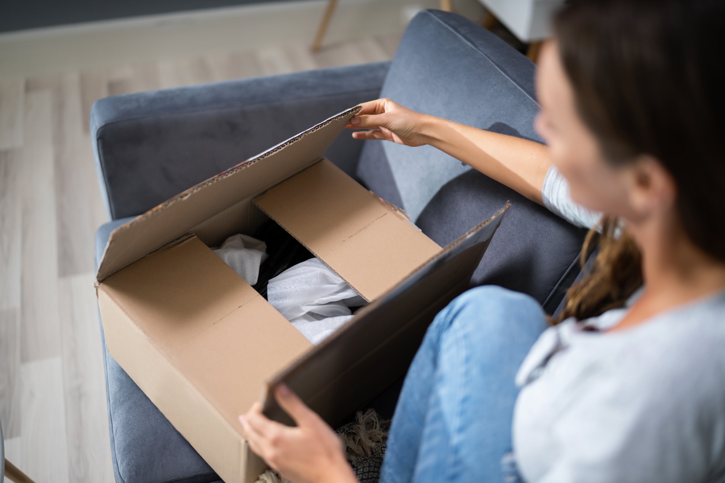 View of a woman's hand opening delivered parcel with picking errors